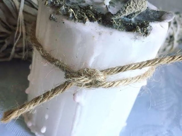 White Pillar candle with sage on top
